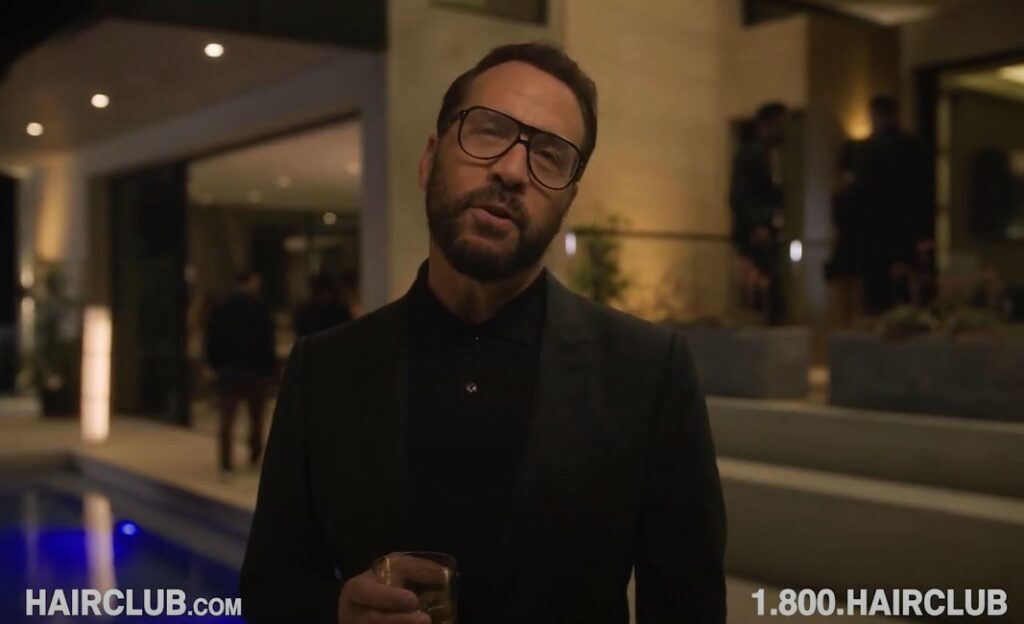 Jeremy Piven at a party situation holding a cup in front of a swimming pool